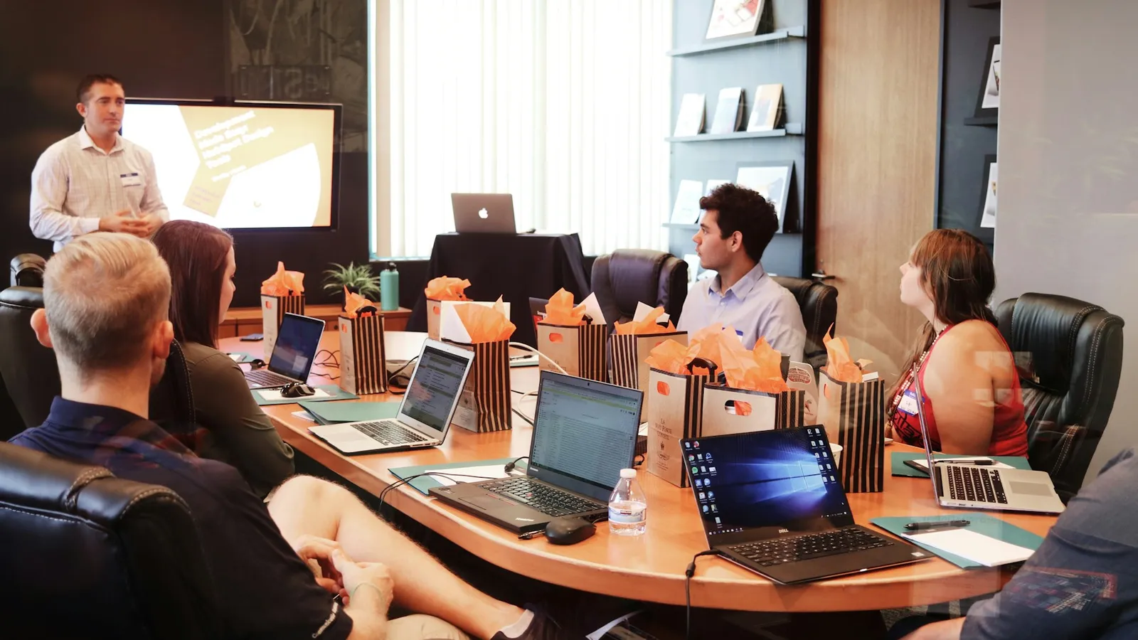 Besprechung an einem Konferenztisch mit Laptops.